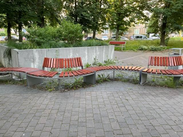 Zarośnięty i zaśmiecony teren pod ławkami w skwerze Tychy Czarnieckiego