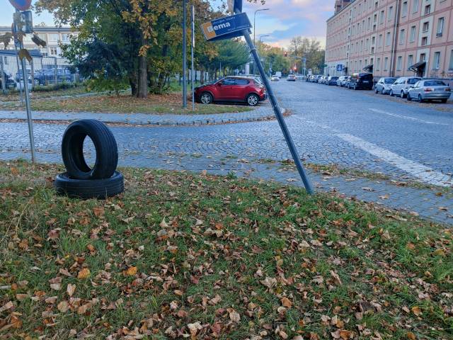 Uszkodzony znak z nazwami ulic.
